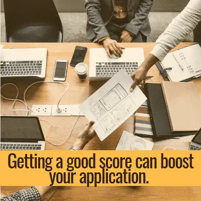 Team reviewing papers: a good essay score can boost your application