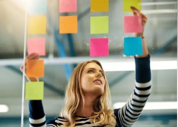 student sticking post-it on board